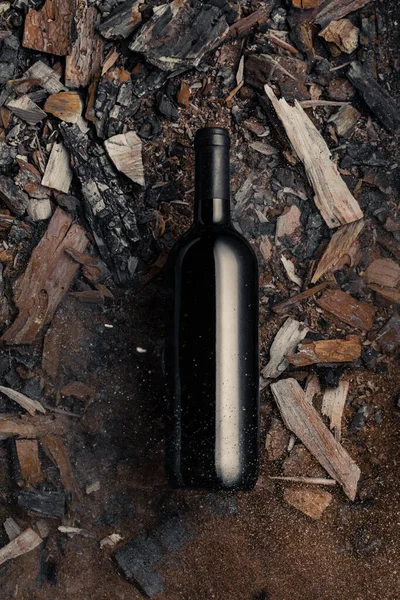 Black bottle with wine with corks on old wood chips background — ストック写真