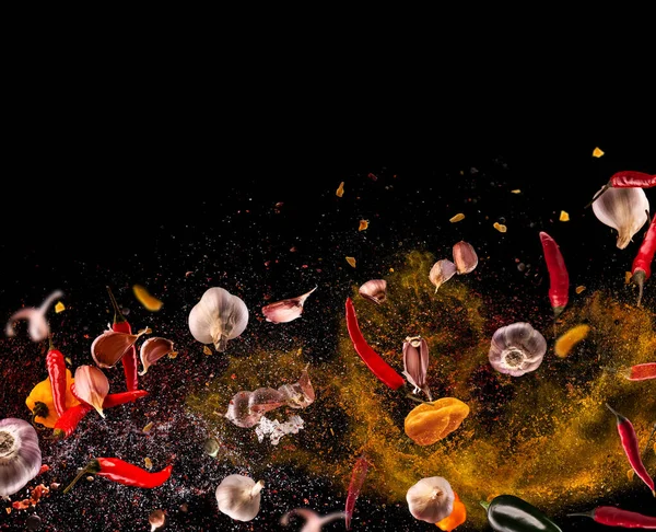 Hot red pepper, garlic, different spices powder meat stakes flying on a black background Motion freeze photo composition — Stock Photo, Image