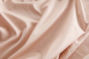 Yumuşak kıvrımlar ve kıvrımlarla yumuşatıcı bir görüntü oluşturan şeftali rengi kumaş zarif bir şekilde düzenlenmiştir. Malzeme öğleden sonra ışıklarını yakalıyor, sıcaklığını ve dokusunu arttırıyor..