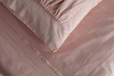 Yumuşak kıvrımlar ve kıvrımlarla yumuşatıcı bir görüntü oluşturan şeftali rengi kumaş zarif bir şekilde düzenlenmiştir. Malzeme öğleden sonra ışıklarını yakalıyor, sıcaklığını ve dokusunu arttırıyor..