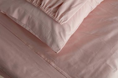 Yumuşak kıvrımlar ve kıvrımlarla yumuşatıcı bir görüntü oluşturan şeftali rengi kumaş zarif bir şekilde düzenlenmiştir. Malzeme öğleden sonra ışıklarını yakalıyor, sıcaklığını ve dokusunu arttırıyor..