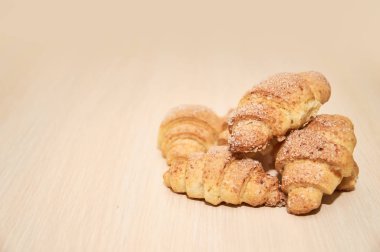 hafif ahşap bir masada taze pişmiş kruvasan