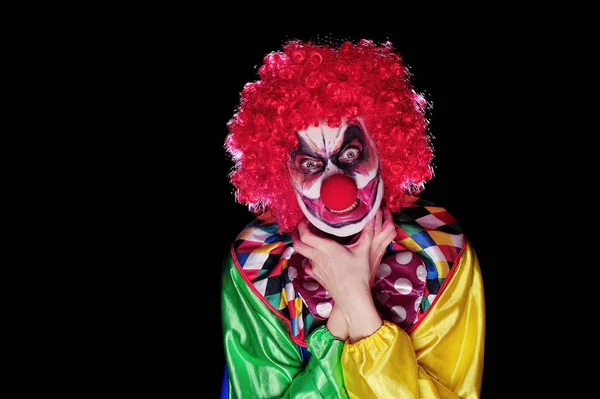 Scary angry clown making threatening gesture
