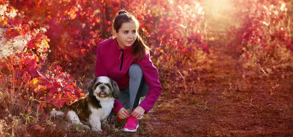 Wide picture of a sporty woman lacing up sneakers