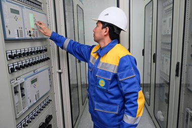 Almaty / Kazakistan - 05.16.2014: Elektrik santrali çalışanları sensörleri kontrol edin. Kontrol gerilimi.