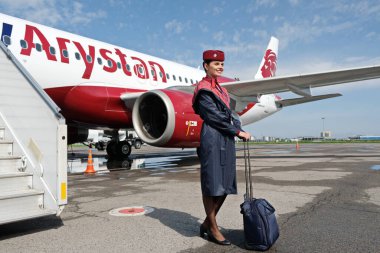 Almaty / Kazakistan - 04.23.2019: Uçağın arka planında bir uçuş görevlisi duruyor. Düşük maliyetli havayolu