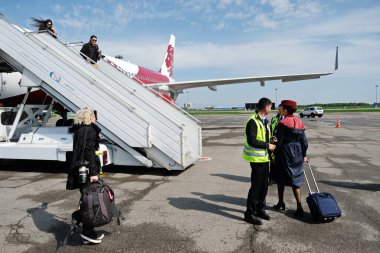 Almaty / Kazakistan - 04.23.2019: Yolcular ve bir uçuş görevlisi uçağın rampasına tırmanacaklar.
