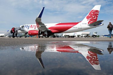 Almaty / Kazakistan - 04.23.2019: Düşük maliyetli Kazakistan havayolu şirketinin uçağı. Sudaki uçağın yansıması..