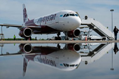 Almaty / Kazakistan - 04.23.2019: Düşük maliyetli Kazakistan havayolu şirketinin uçağı. Sudaki uçağın yansıması..