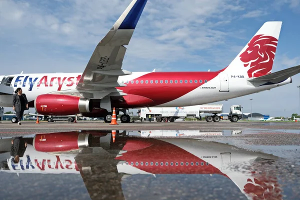 Almaty / Kazakistan - 04.23.2019: Düşük maliyetli Kazakistan havayolu şirketinin uçağı. Sudaki uçağın yansıması..