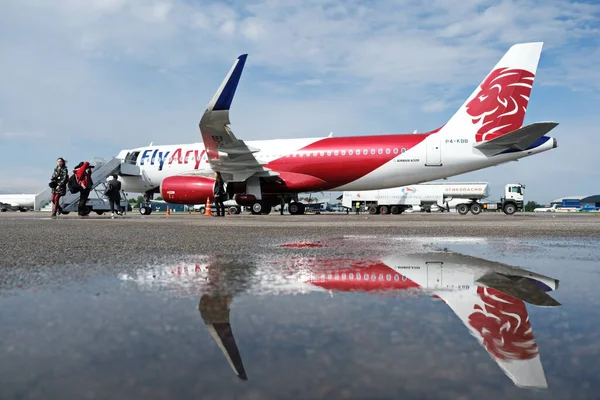 Almaty / Kazakistan - 04.23.2019: Düşük maliyetli Kazakistan havayolu şirketinin uçağı. Sudaki uçağın yansıması..