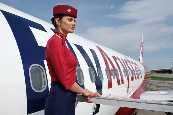 Almaty / Kazakistan - 04.23.2019: Uçağın arka planında bir uçuş görevlisi duruyor. Düşük maliyetli havayolu