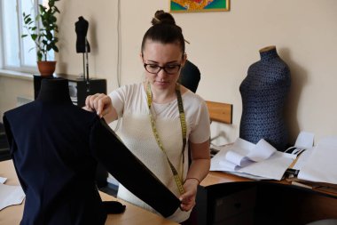 Almaty / Kazakistan - 04.09.2019: Şehir giyim üretiminde küçük işletme. Çalışanlar, mavi üniformaları ütülemek ve dikmek için desen hazırlıyorlar..