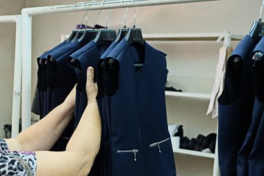 Almaty / Kazakistan - 04.09.2019: Şehir giyim üretiminde küçük işletme. Çalışanlar, mavi üniformaları ütülemek ve dikmek için desen hazırlıyorlar..