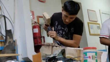 Yayın materyali Almaty / Kazakistan - 06.17.2020: Kazak ulusal enstrümanlarının üretimi için atölye. Ustalar dombra yapar: ahşap, cila, boya ve ipleri keserler..