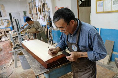 Almaty / Kazakistan - 06.17.2020: Ahşaptan yapılmış Kazak ulusal müzik enstrümanları için atölye. Parçaları kesme, birleştirme ve boyama.