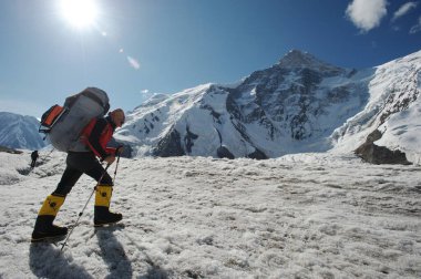 Khan Tengri / Kazakistan - 07.27.2011: Tırmanışçılar Khan Tengri dağının eteklerine giderler. Zirveye yükselişin başlangıcı.