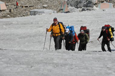 Khan Tengri / Kazakistan - 07.27.2011: Tırmanışçılar Khan Tengri dağının eteklerine giderler. Zirveye yükselişin başlangıcı.