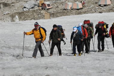 Khan Tengri / Kazakistan - 07.27.2011: Tırmanışçılar Khan Tengri dağının eteklerine giderler. Zirveye yükselişin başlangıcı.