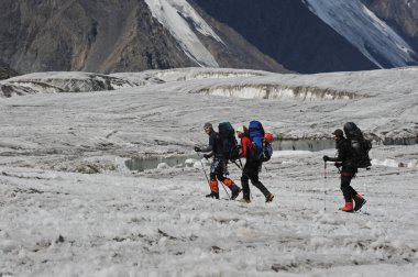 Khan Tengri / Kazakistan - 07.27.2011: Tırmanışçılar Khan Tengri dağının eteklerine giderler. Zirveye yükselişin başlangıcı.
