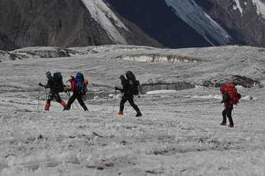 Khan Tengri / Kazakistan - 07.27.2011: Tırmanışçılar Khan Tengri dağının eteklerine giderler. Zirveye yükselişin başlangıcı.