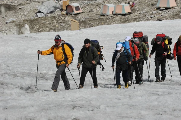 Khan Tengri / Kazakistan - 07.27.2011: Tırmanışçılar Khan Tengri dağının eteklerine giderler. Zirveye yükselişin başlangıcı.