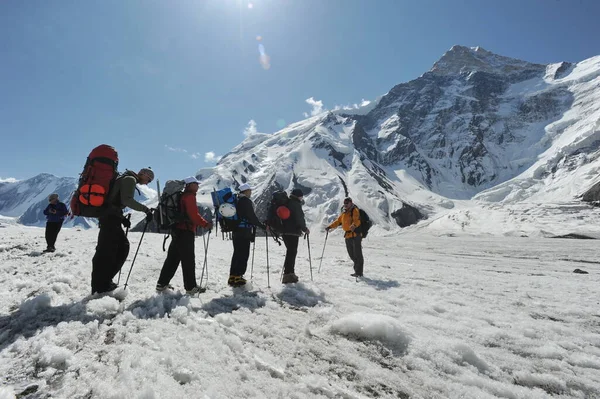 Khan Tengri / Kazakistan - 07.27.2011: Tırmanışçılar Khan Tengri dağının eteklerine giderler. Zirveye yükselişin başlangıcı.