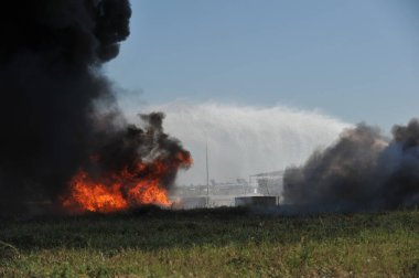 Almaty / Kazakistan - 09.05.2011: Havaalanında itfaiye eğitimi. Kurtarma ekibi yangının yerini belirleyip yangını söndürüyor..