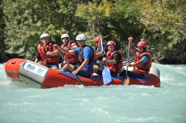 Almaty / Kazakistan - 09.03.2011: Sallar ve şişme botlarla bir dağ nehrinde rafting. Bir grup insan dalgalarla kürekleri kontrol ediyor.
