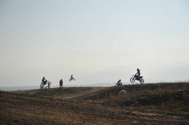 Almaty / Kazakistan - 10.22.2011: Motokros yarışmaları. Sporcular tekerleklerden yapılmış engellerle pisti geçiyorlar