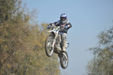 Almaty / Kazakistan - 10.22.2011: Motokros yarışmaları. Sporcular tekerleklerden yapılmış engellerle pisti geçiyorlar