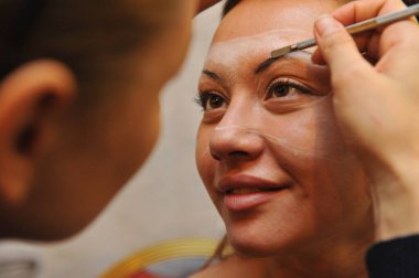 Almaty / Kazakistan - 11.26.2011: Makyöz, modelin yüzü ve vücuduna bir model çiziyor. Sanatsal bir resim oluşturuluyor