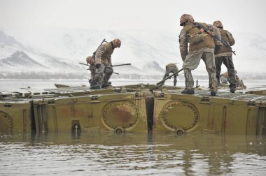 Almaty bölgesi / Kazakistan - 02.29.2012: Askerler nehri geçmek için metal bir yapı oluşturuyorlar. Kazakistan mühendislik birliklerinin tatbikatları.