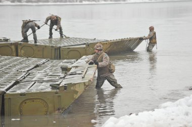 Almaty bölgesi / Kazakistan - 02.29.2012: Askerler nehri geçmek için metal bir yapı oluşturuyorlar. Kazakistan mühendislik birliklerinin tatbikatları.