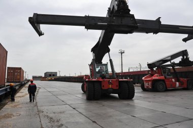 Almaty bölgesi / Kazakistan - 04.11.2012: Bir vinç sıralama konteynırına sahip özel ulaşım. Demiryolu kavşağı