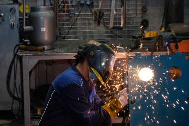 Almaty / Kazakistan - 08.18.2020: Metal yapılar fabrikasının işçileri boru kaynakçılığıyla meşgul