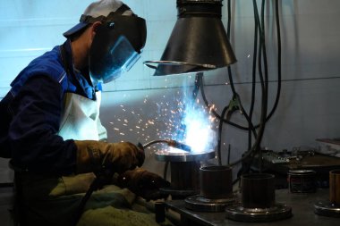 Almaty / Kazakistan - 08.18.2020: Metal yapılar fabrikasının işçileri boru kaynakçılığıyla meşgul