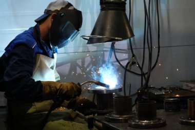 Almaty / Kazakistan - 08.18.2020: Metal yapılar fabrikasının işçileri boru kaynakçılığıyla meşgul