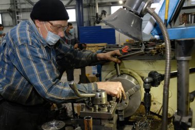 Almaty / Kazakistan - 08.18.2020: Metal yapılar üretimi için bir fabrikada çalışan yaşlı bir işçi. Editör materyali 