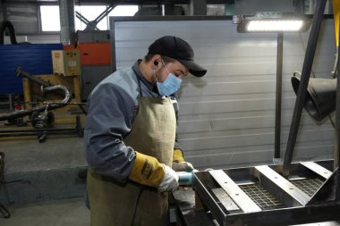 Almaty / Kazakistan - 08.18.2020: Metal yapılar fabrikasının işçileri boru kaynakçılığı ile ilgileniyorlar 