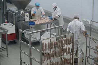 Almaty / Kazakistan - 08.18.2020: Sosis ve et ürünleri üretimi için fabrikanın işçileri kontrol ve paketleme ürünleri