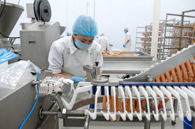 Almaty / Kazakistan - 08.18.2020: Sosis ve et ürünleri üretimi için fabrikanın işçileri kontrol ve paketleme ürünleri