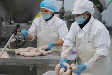 Almaty / Kazakistan - 08.18.2020: Sosis ve et ürünleri üretimi için fabrikanın işçileri kontrol ve paketleme ürünleri