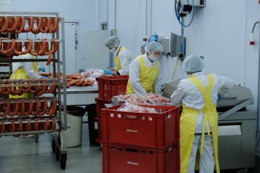 Almaty / Kazakistan - 08.18.2020: Sosis ve et ürünleri üretimi için fabrikanın işçileri kontrol ve paketleme ürünleri
