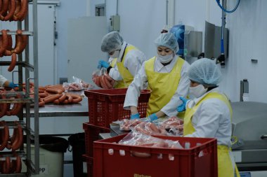 Almaty / Kazakistan - 08.18.2020: Sosis ve et ürünleri üretimi için fabrikanın işçileri kontrol ve paketleme ürünleri