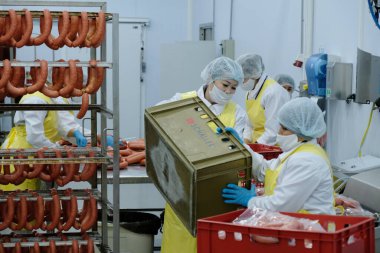 Almaty / Kazakistan - 08.18.2020: Sosis ve et ürünleri üretimi için fabrikanın işçileri kontrol ve paketleme ürünleri