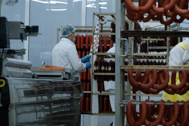 Almaty / Kazakistan - 08.18.2020: Sosis ve et ürünleri üretimi için fabrikanın işçileri kontrol ve paketleme ürünleri