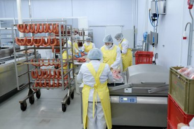 Almaty / Kazakistan - 08.18.2020: Sosis ve et ürünleri üretimi için fabrikanın işçileri kontrol ve paketleme ürünleri