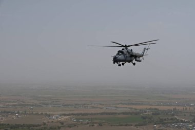 Almaty / Kazakistan - 08.25.2020: Konut binaları, çeşitli altyapı ve tarım arazileri olan bir şehir üzerinde askeri helikopterin kalkışı.