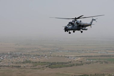 Almaty / Kazakistan - 08.25.2020: Konut binaları, çeşitli altyapı ve tarım arazileri olan bir şehir üzerinde askeri helikopterin kalkışı.